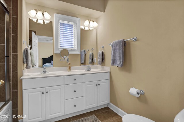 bathroom with toilet, tile patterned flooring, and a sink