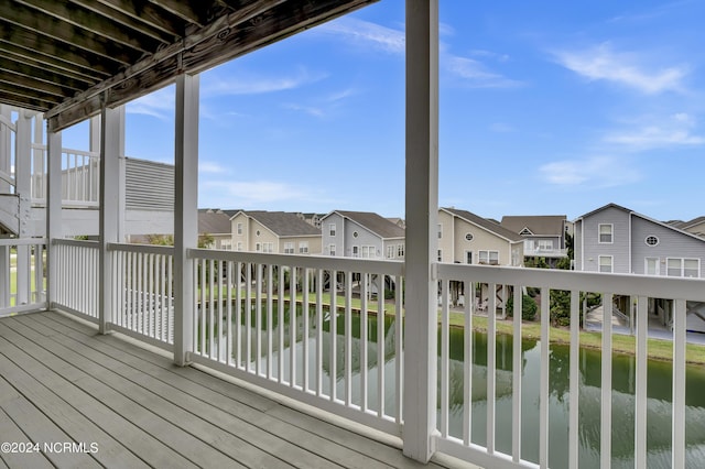 wooden deck featuring a water view and a residential view