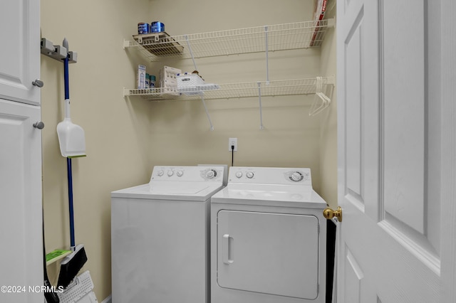 laundry room featuring washing machine and clothes dryer and cabinet space