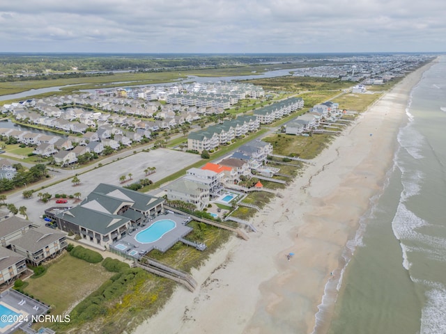 birds eye view of property with a water view and a view of the beach