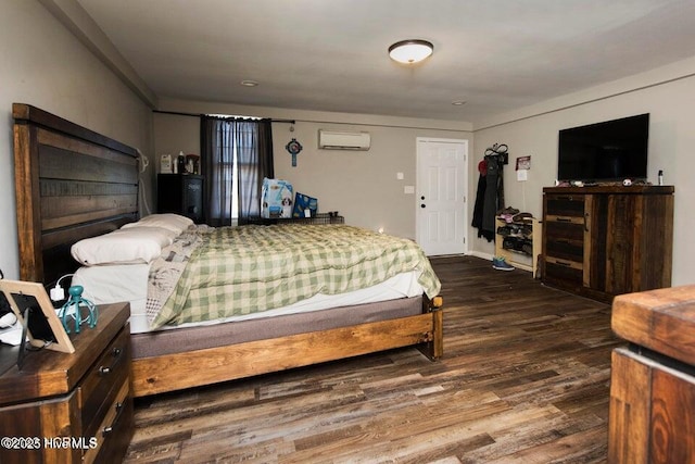 bedroom with a wall mounted air conditioner and wood finished floors