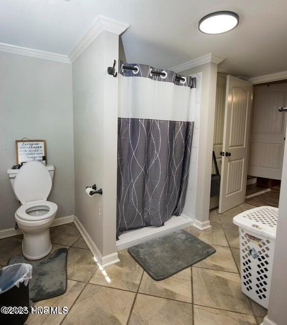 bathroom featuring toilet, a stall shower, baseboards, and ornamental molding