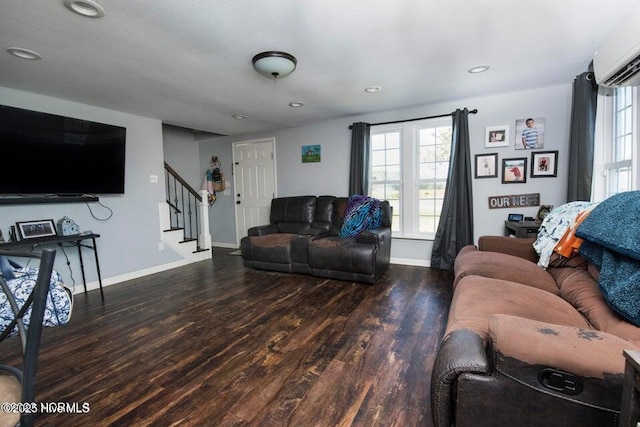 living area featuring a wealth of natural light, stairway, an AC wall unit, and wood finished floors