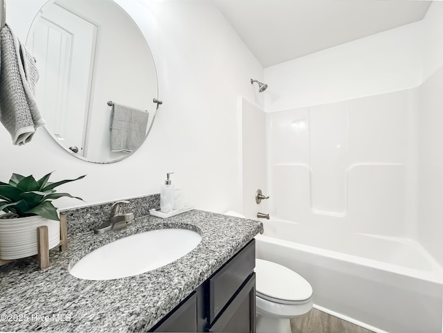 bathroom featuring wood finished floors, bathing tub / shower combination, vanity, and toilet