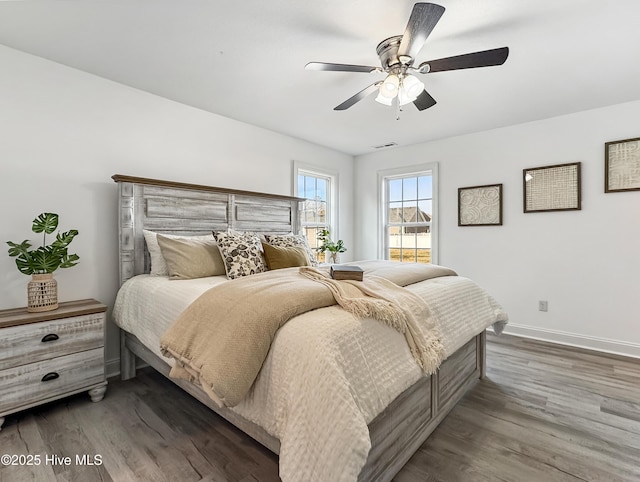 bedroom with visible vents, ceiling fan, baseboards, and wood finished floors