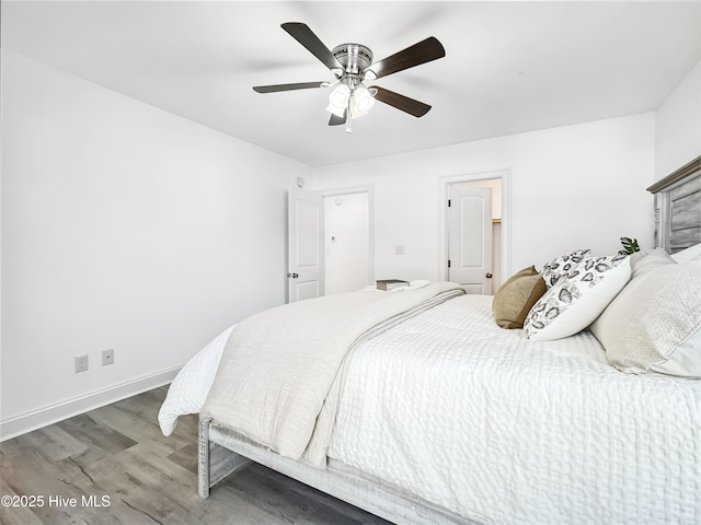 bedroom featuring ceiling fan, baseboards, and wood finished floors