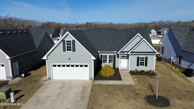 traditional-style house with a garage, cooling unit, concrete driveway, and roof with shingles