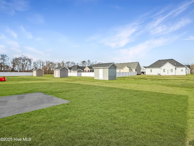 view of yard featuring an outbuilding, a residential view, and a storage shed