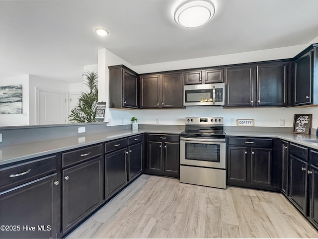 kitchen featuring stainless steel appliances, light countertops, and light wood-style flooring