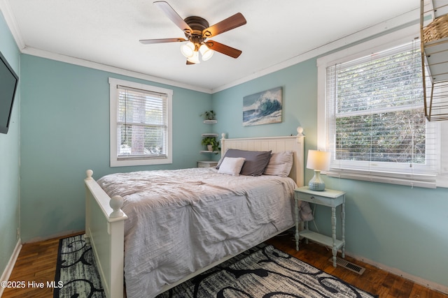 bedroom featuring baseboards, a ceiling fan, wood finished floors, and crown molding