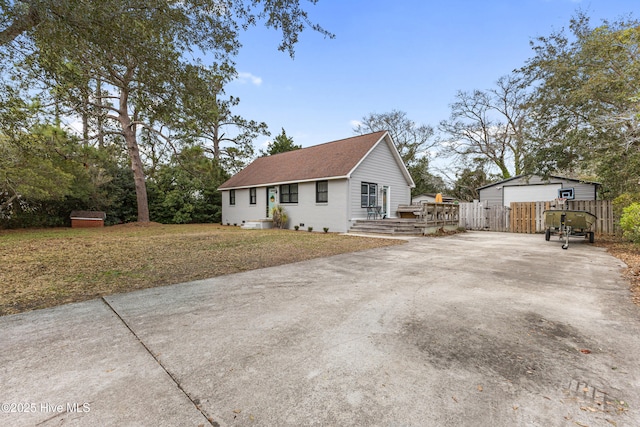 view of home's exterior featuring fence, a wooden deck, concrete driveway, a lawn, and crawl space