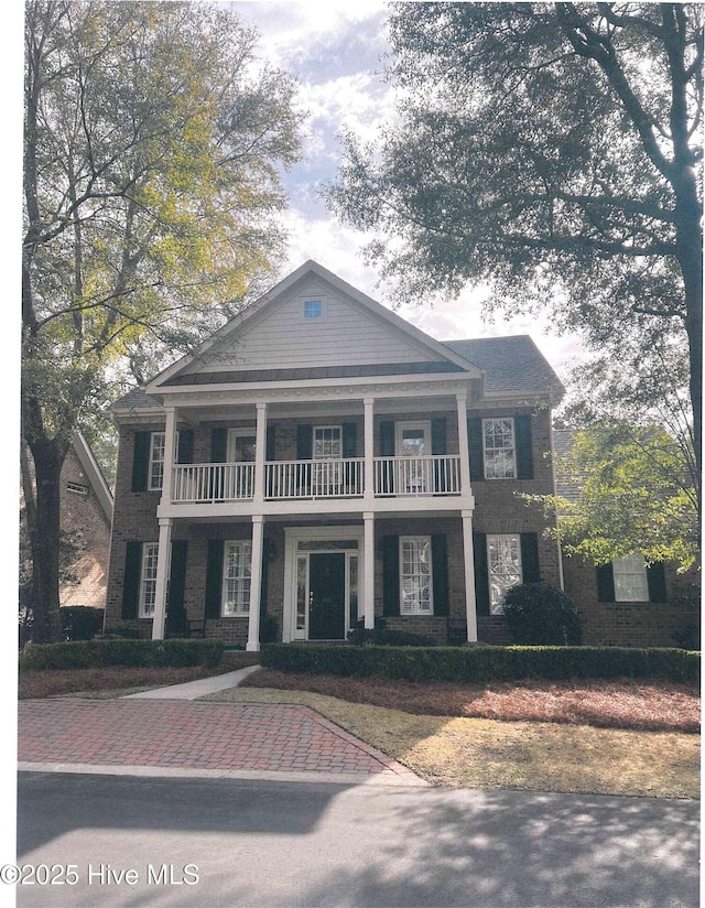 greek revival house featuring a balcony and a porch