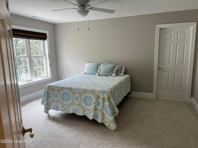 bedroom featuring a ceiling fan, visible vents, baseboards, and light carpet