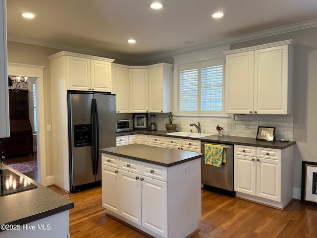 kitchen with a sink, dark countertops, dark wood-style floors, and stainless steel appliances