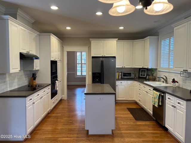 kitchen featuring a sink, dark countertops, black appliances, and under cabinet range hood