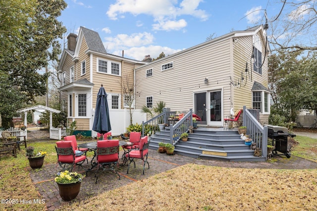 back of property featuring a wooden deck and a chimney