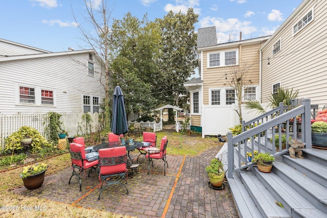 view of patio with outdoor dining space and fence