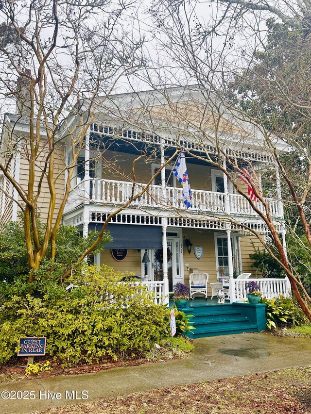 back of house with a porch and a balcony