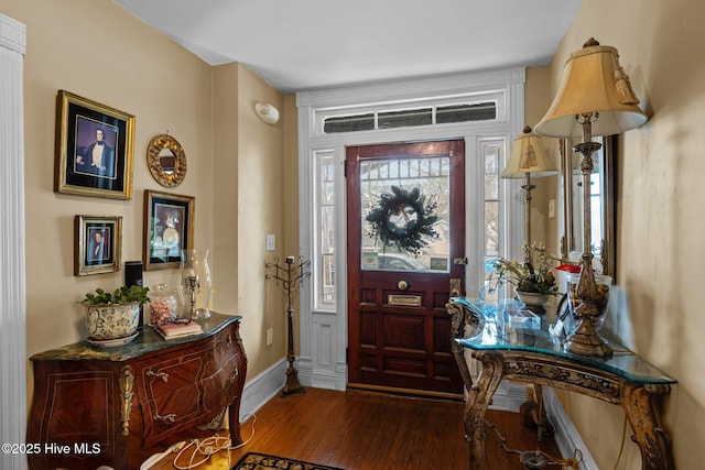 entryway with baseboards and wood finished floors