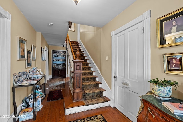 stairs featuring wood finished floors and baseboards