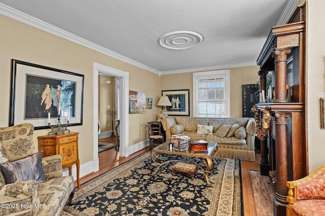 living area with wood finished floors, baseboards, and ornamental molding