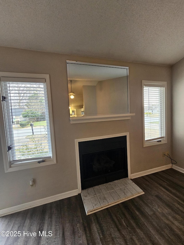 unfurnished living room featuring a textured ceiling, a fireplace, and wood finished floors