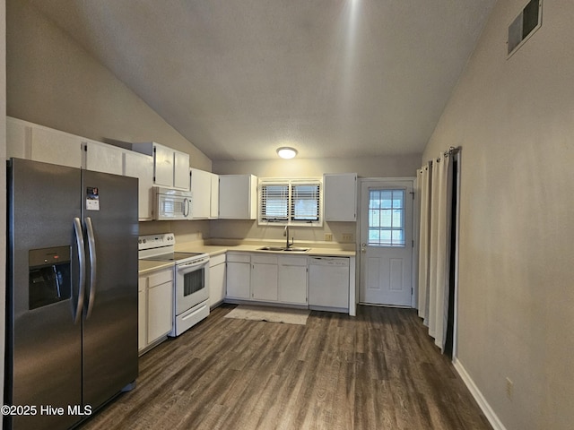 kitchen with white appliances, visible vents, dark wood-style floors, light countertops, and a sink