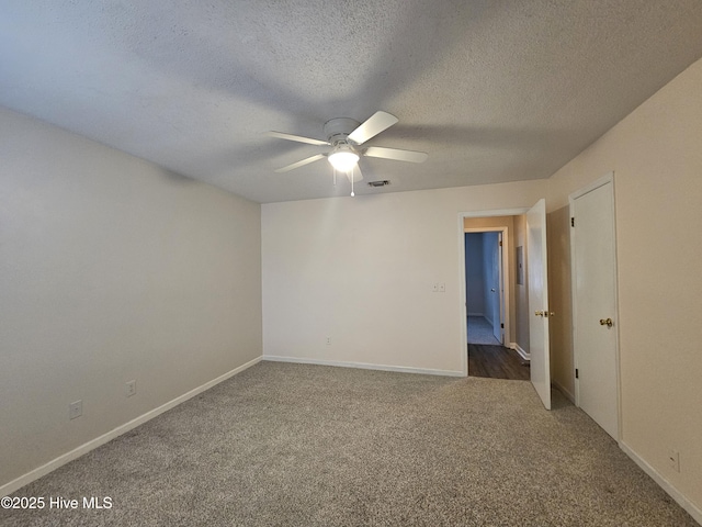 empty room with baseboards, visible vents, ceiling fan, a textured ceiling, and carpet flooring