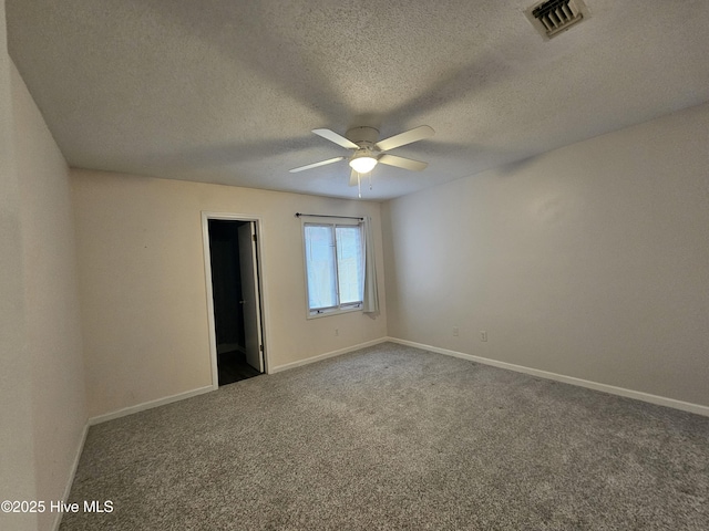 spare room featuring carpet flooring, visible vents, and baseboards