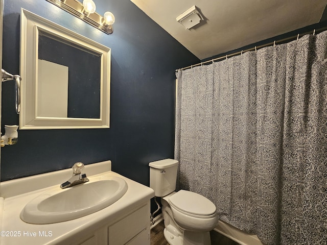 bathroom featuring a shower with shower curtain, vaulted ceiling, vanity, and toilet