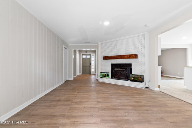 unfurnished living room featuring light wood-style floors, a fireplace, and baseboards