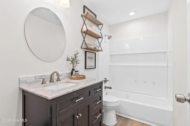 bathroom featuring shower / washtub combination, vanity, toilet, and wood finished floors