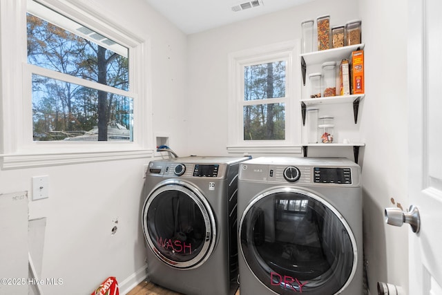 laundry area with laundry area, visible vents, and washing machine and clothes dryer