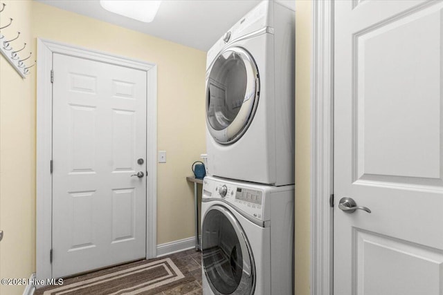 laundry area featuring stacked washer / dryer, laundry area, and baseboards