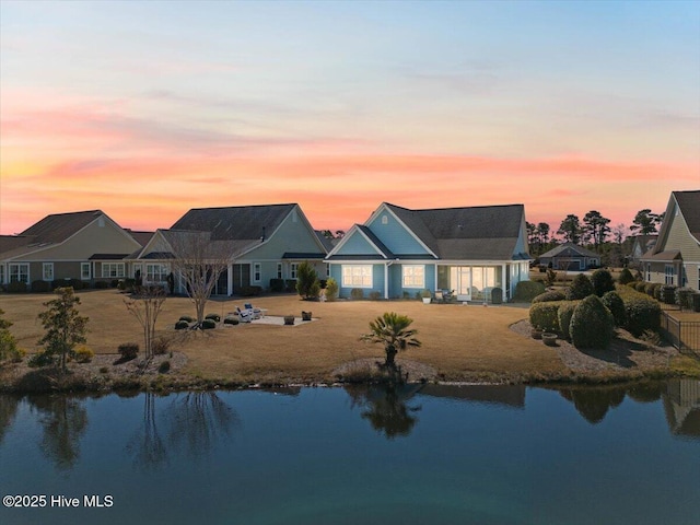 exterior space with a water view and a lawn