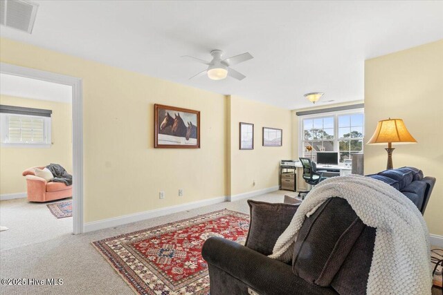 living area featuring a ceiling fan, carpet flooring, visible vents, and baseboards