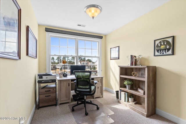 office featuring visible vents, light carpet, and baseboards