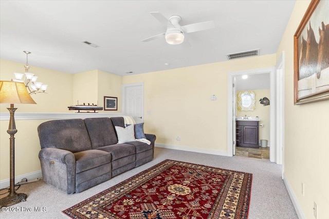 carpeted living room featuring ceiling fan with notable chandelier, visible vents, and baseboards