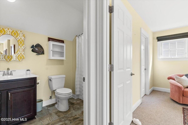 bathroom featuring toilet, baseboards, vaulted ceiling, and vanity