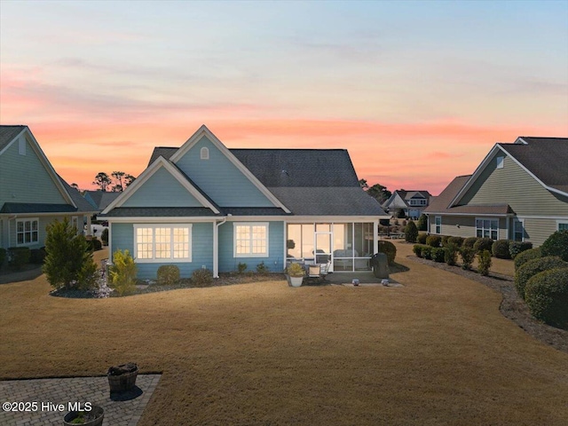 view of front facade featuring a yard and a sunroom