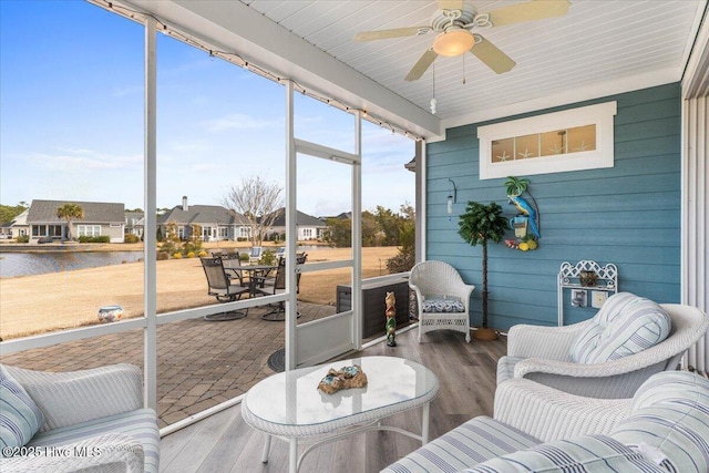 sunroom with a water view and ceiling fan