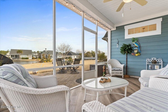 sunroom with a ceiling fan and a residential view