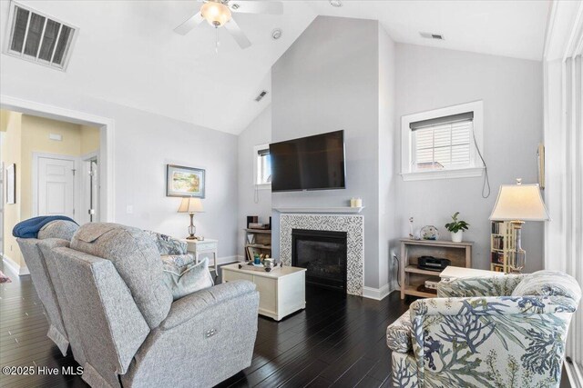 living area with dark wood-style flooring, visible vents, and a healthy amount of sunlight