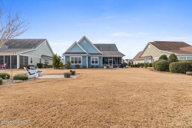 rear view of property featuring a sunroom and a yard