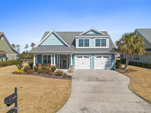 view of front of property with an attached garage, covered porch, a front lawn, and concrete driveway