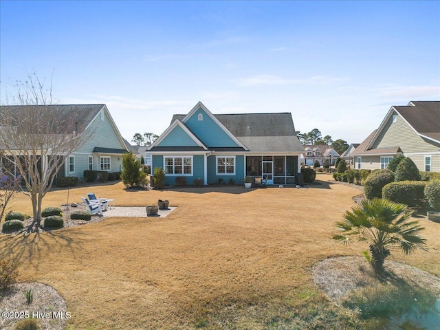 rear view of house with a yard and a sunroom