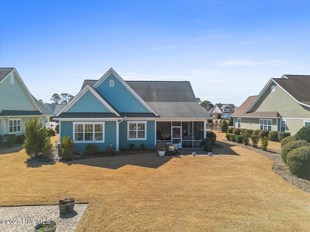 view of front of house with a sunroom and a front lawn