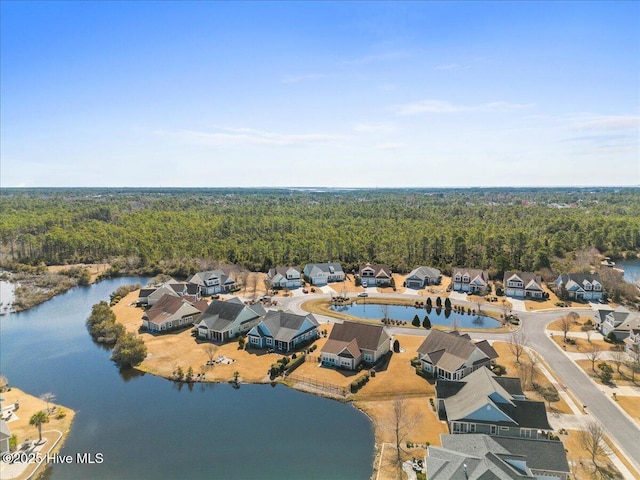 aerial view featuring a forest view, a water view, and a residential view