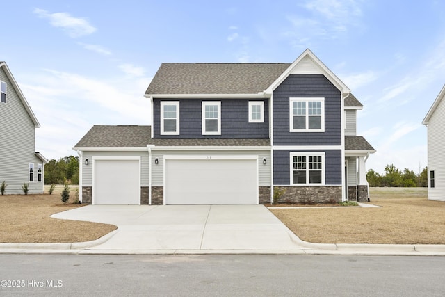 craftsman-style home featuring stone siding, driveway, and roof with shingles