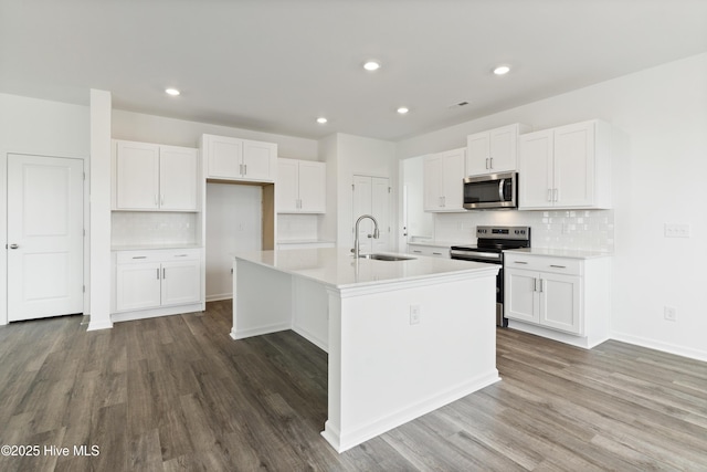 kitchen featuring dark wood-style flooring, white cabinets, appliances with stainless steel finishes, and a sink